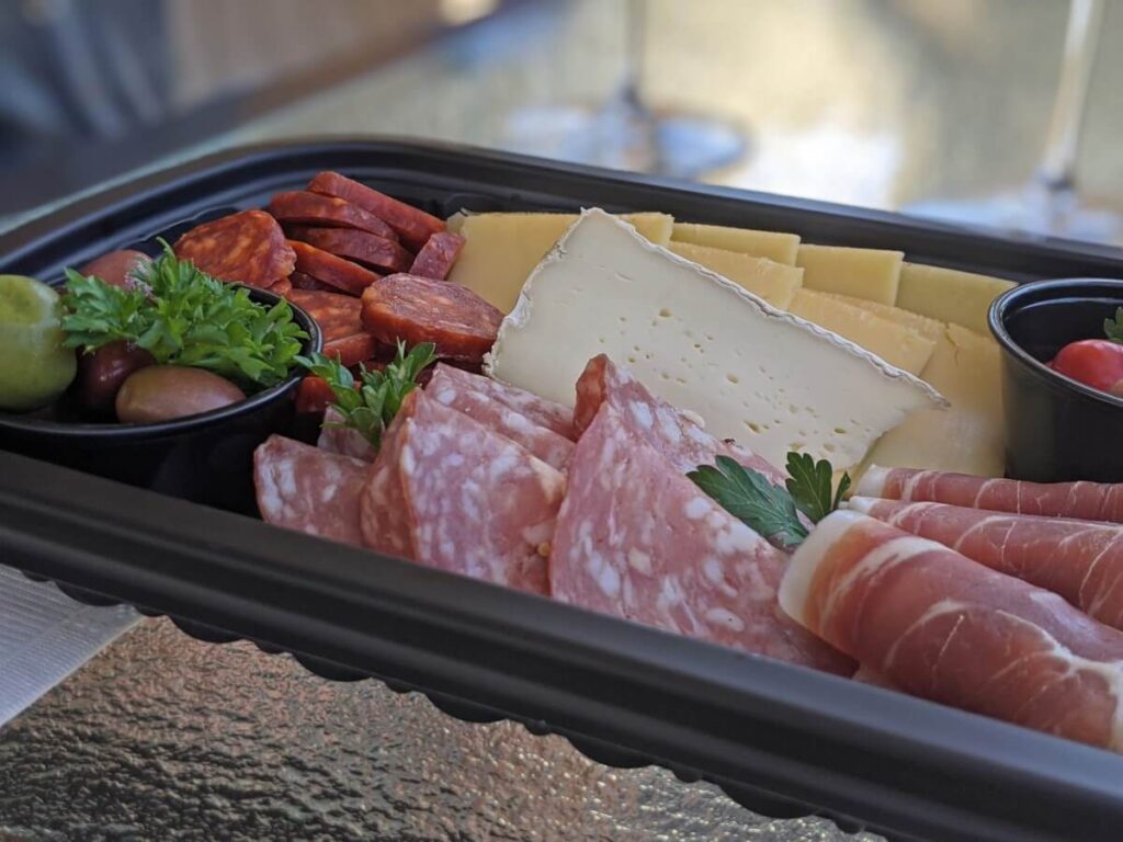 Close up of Howling Bluff charcuterie container, with meat, cheese and olives