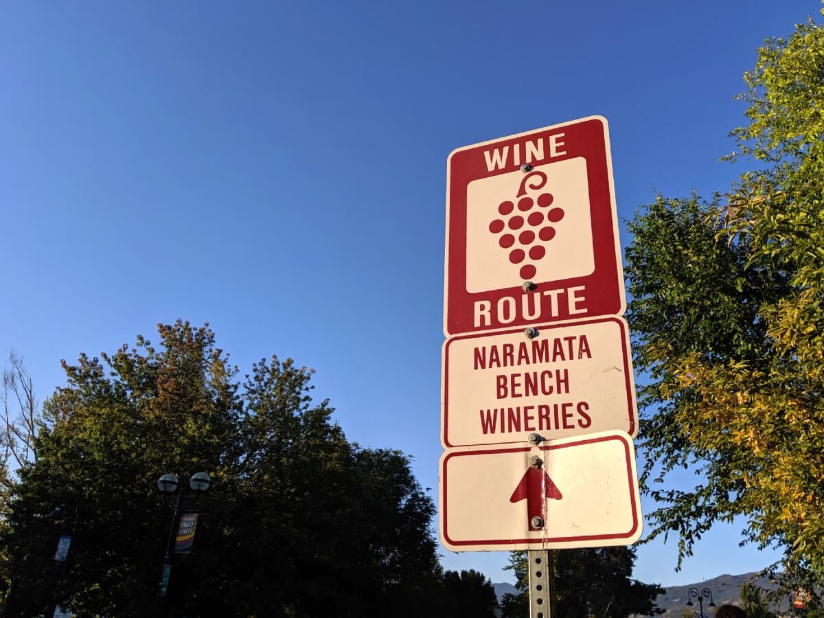Close up of Naramata Bench direction sign, with arrow and image of wine grapes
