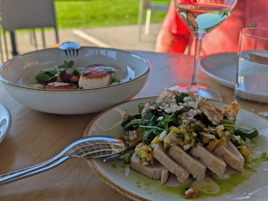 Close up of two dishes at Poplar Grove Restaurant on the Naramata Bench, with wine glass on right
