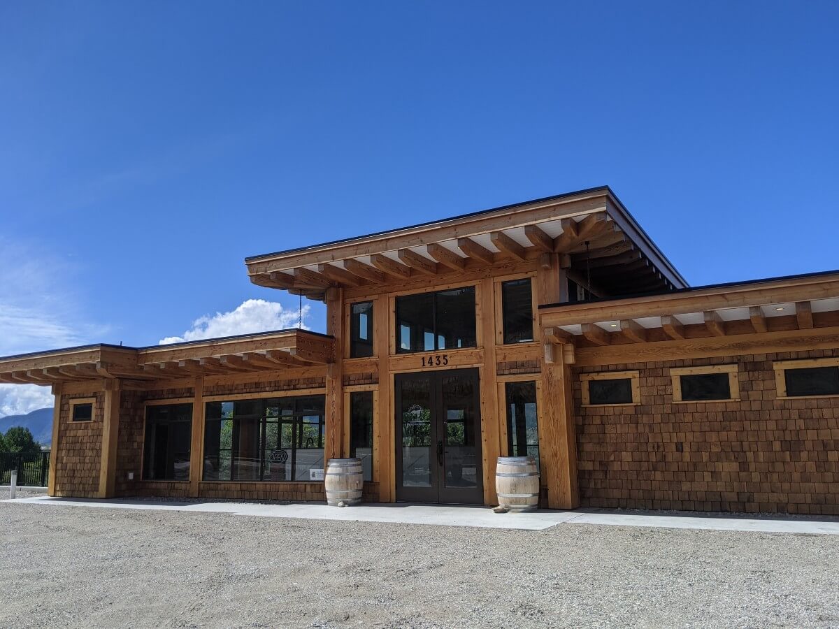 Front view of single story Singletree Winery with large glass doors and wooden shingling on outside walls