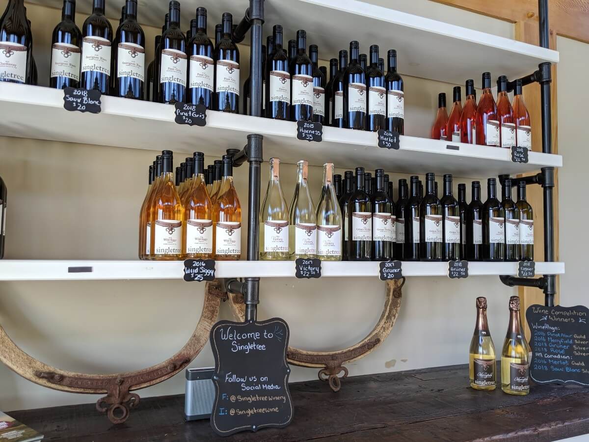View of shelving in Singletree Winery with wine bottles and pricing