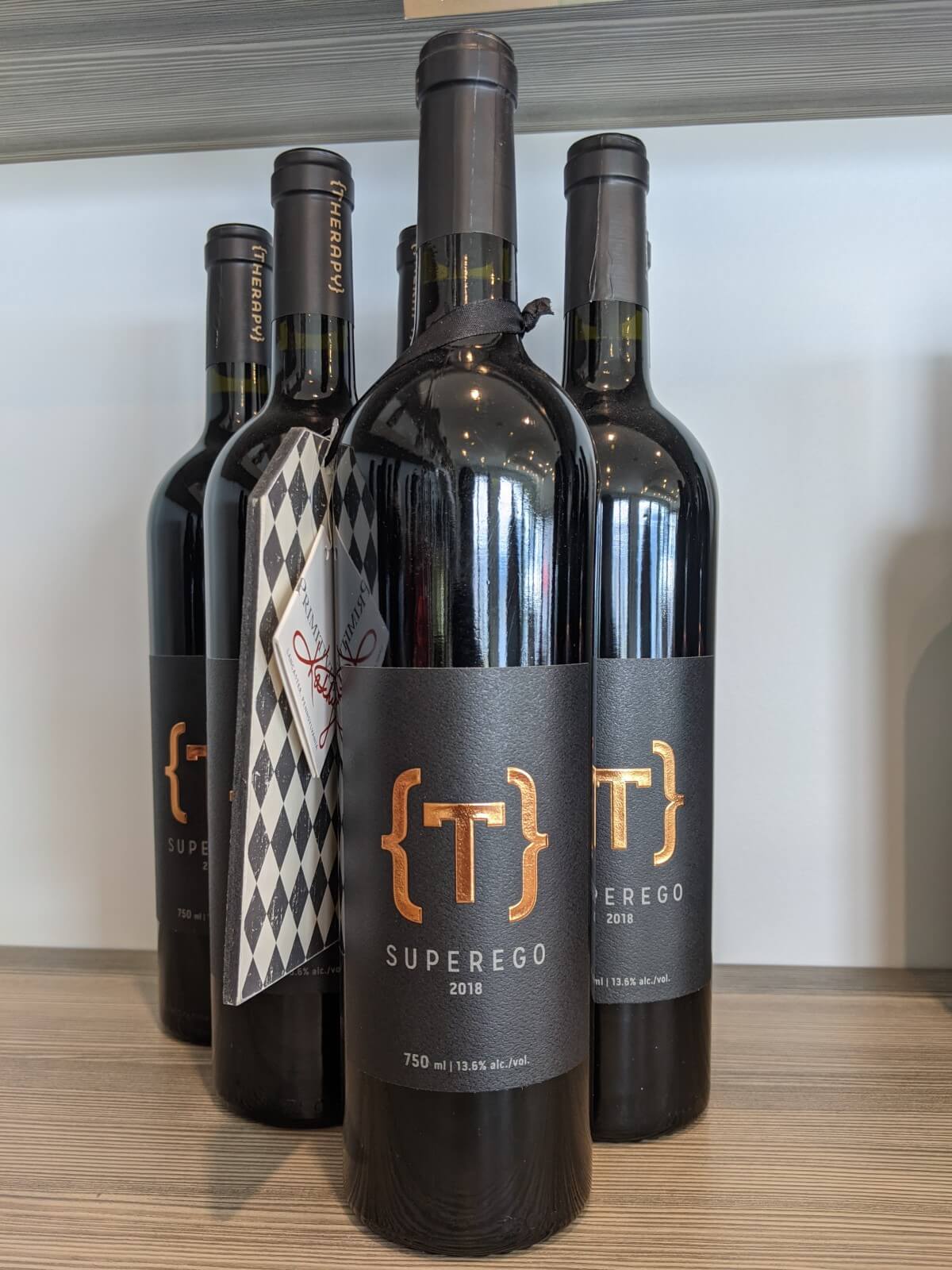 Close up of Super Ego wine bottles at Therapy Vineyards, with five bottles lined up in a pyramid formation