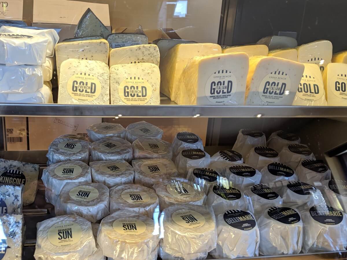 Close up of cheese cabinet at Upper Bench Winery, with two rows of individually wrapped cheese