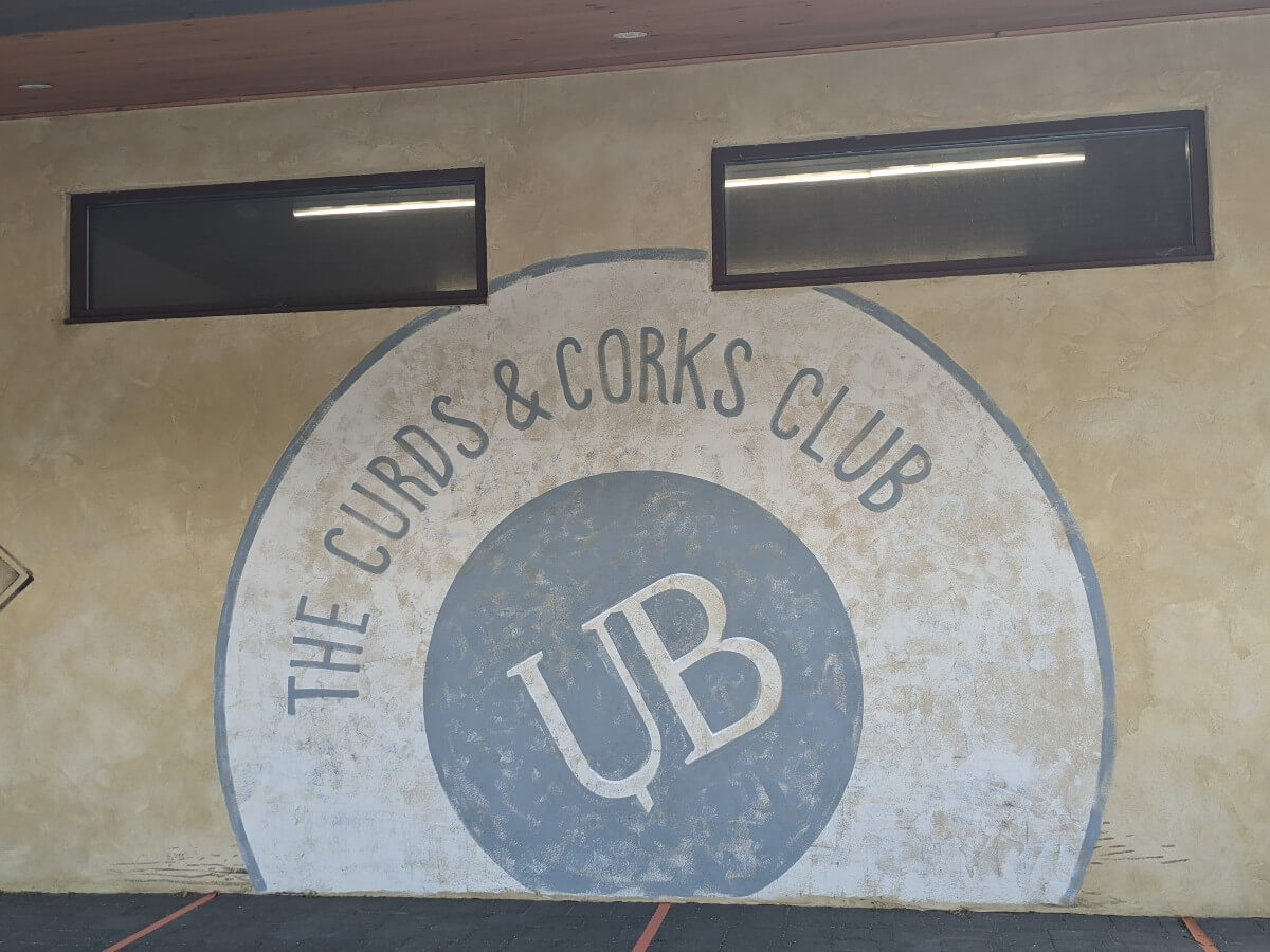 Curds and Cork Club artwork on side of Upper Bench building