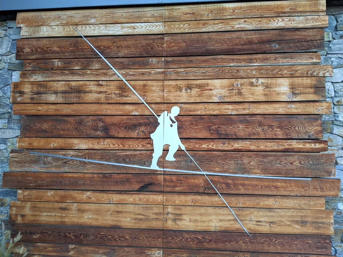 Close up of Tightrope logo (a silhouette of a man on a tightrope) on wooden planks