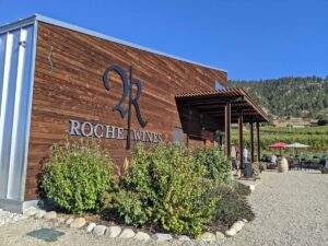 Roche Wines tasting room, a two storey building with a sloped roof and wooden panels along the side, with winery logo