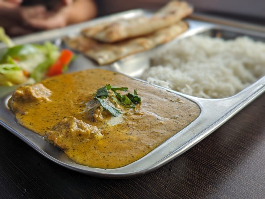 Close up shot of combination plate at Ashoka Indian Cuisine with curry, rice, salad and naan bread