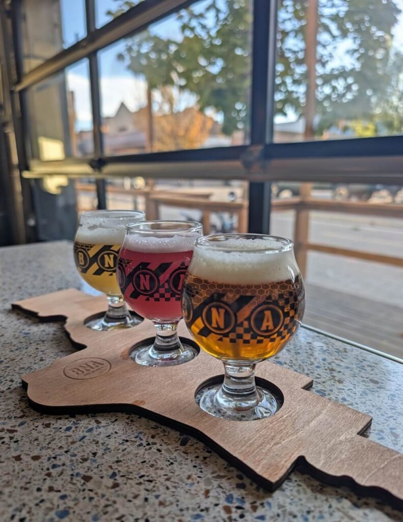 Close up of three glass beer flight at BNA brewing on table