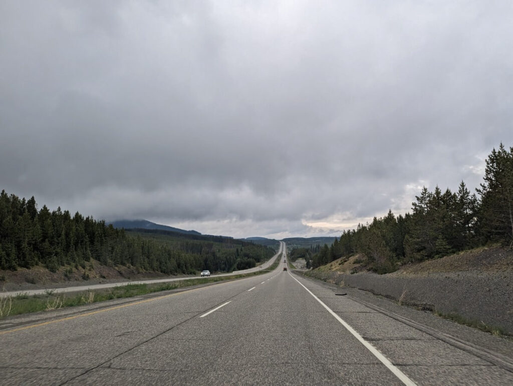 Vehicle view of Highway 97C stretching into distance, cloudy skies