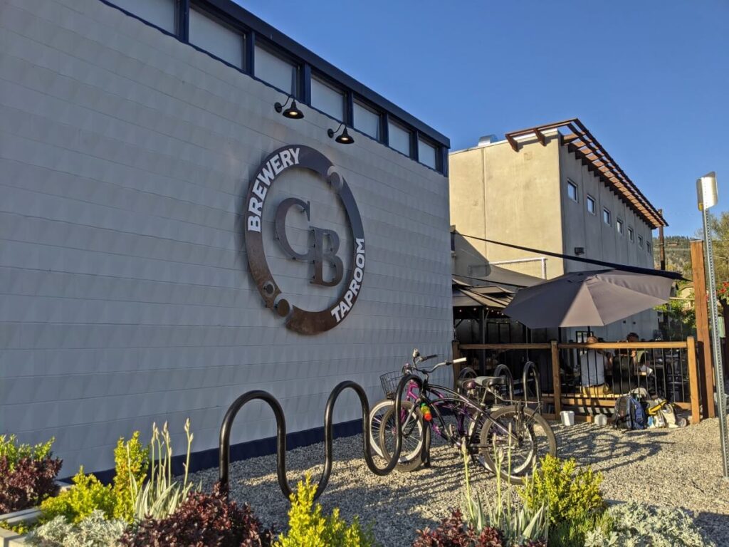 Exterior of Cannery Brewing Taproom building with logo on side, bike rack and patio