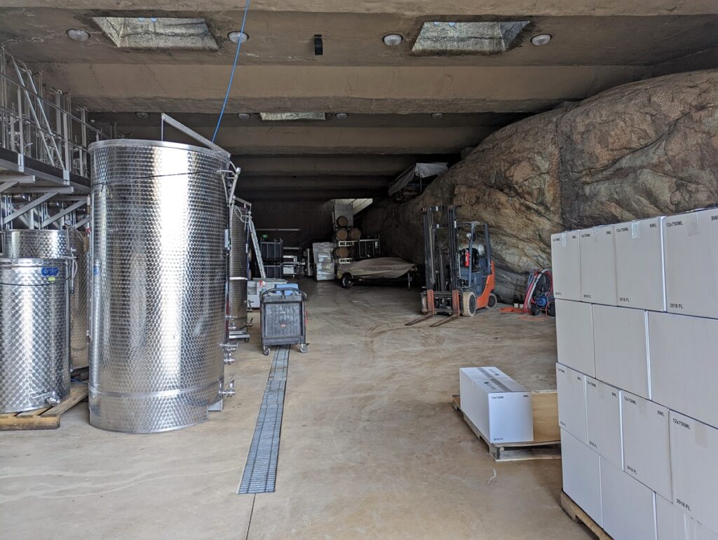 Looking into Pentâge's huge natural rock cellar with stainless steel continers on left, forklift on right and bare rock wall behind