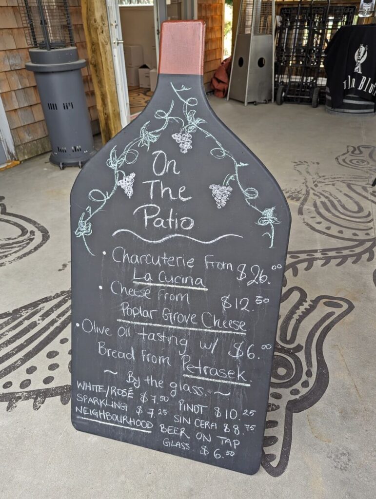 Patio blackboard sign at Howling Bluff Winery with charcuterie, cheese, olive oil tasting and wine by the glass prices