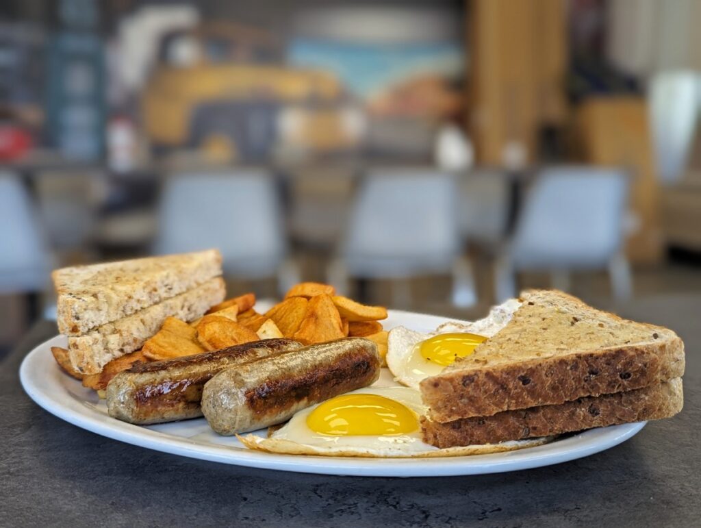 Close up of breakfast dish at Tootsies Diner, featuring toast, susages, fried eggs and hashbrowns