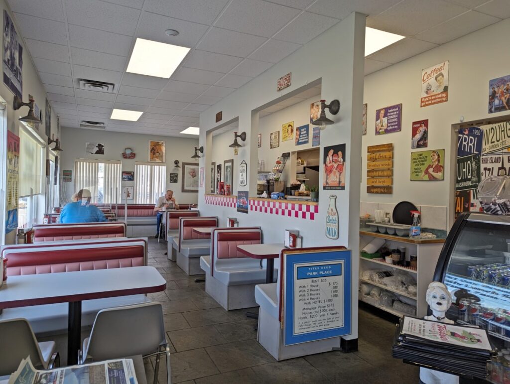 Tootsies Diner interior view with 1950s style diner seats, vintage signs on walls 