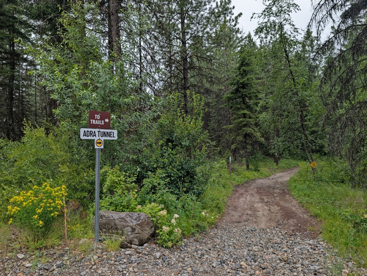 Dirt bike trail leading into forest wioth Adra Tunnel sign on left