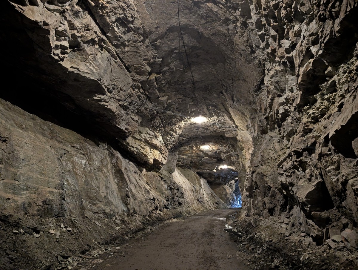 Lit up view of Adra Tunnel interior, with rugged rock walls, tall ceilings, LED lighting