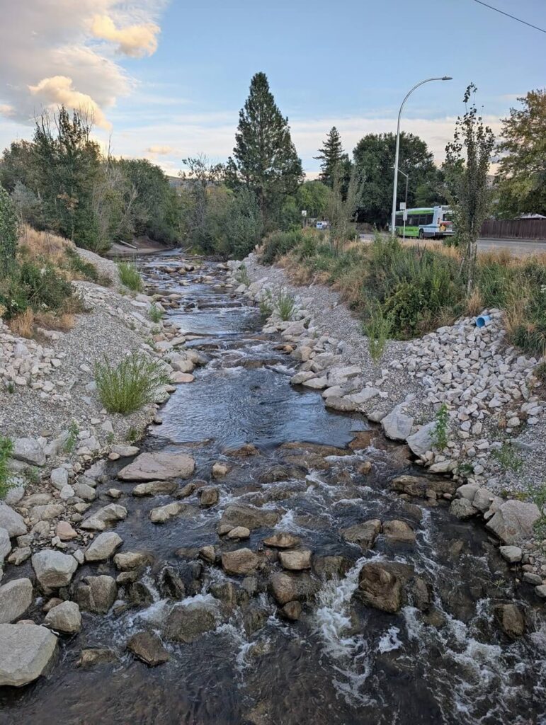 View of one of the restored sections of Penticton Creek from footbridge, lookign down on rocky river channel