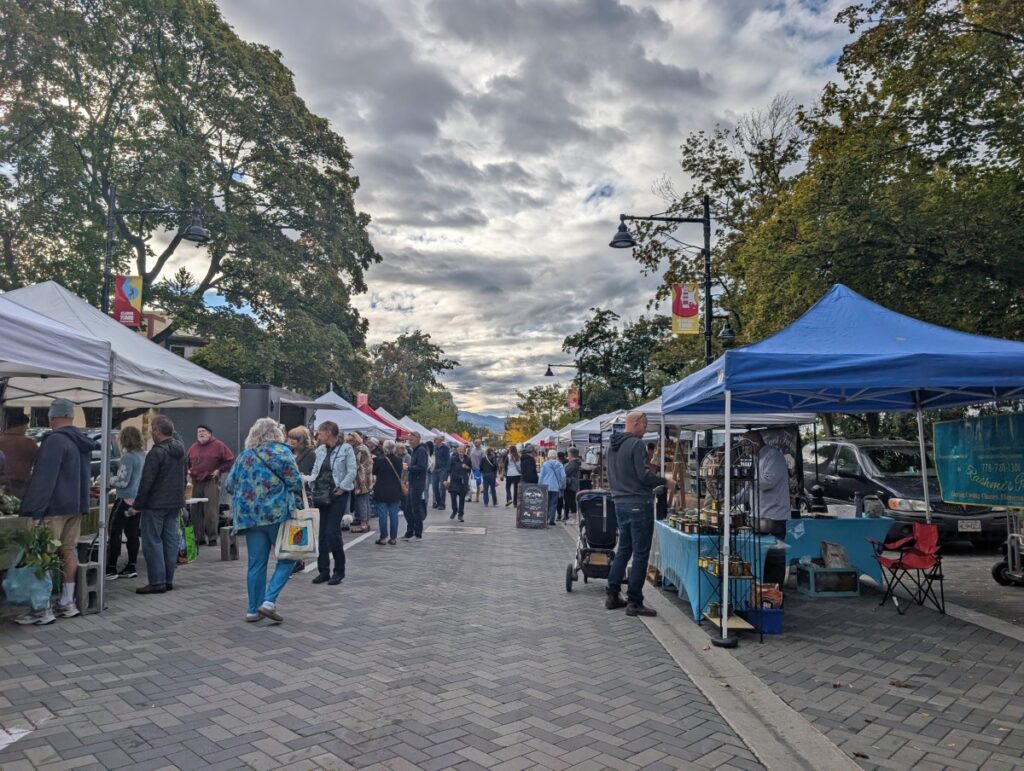 Looking down pedestrianised street with market stalls in Penticton. Trees lined the street
