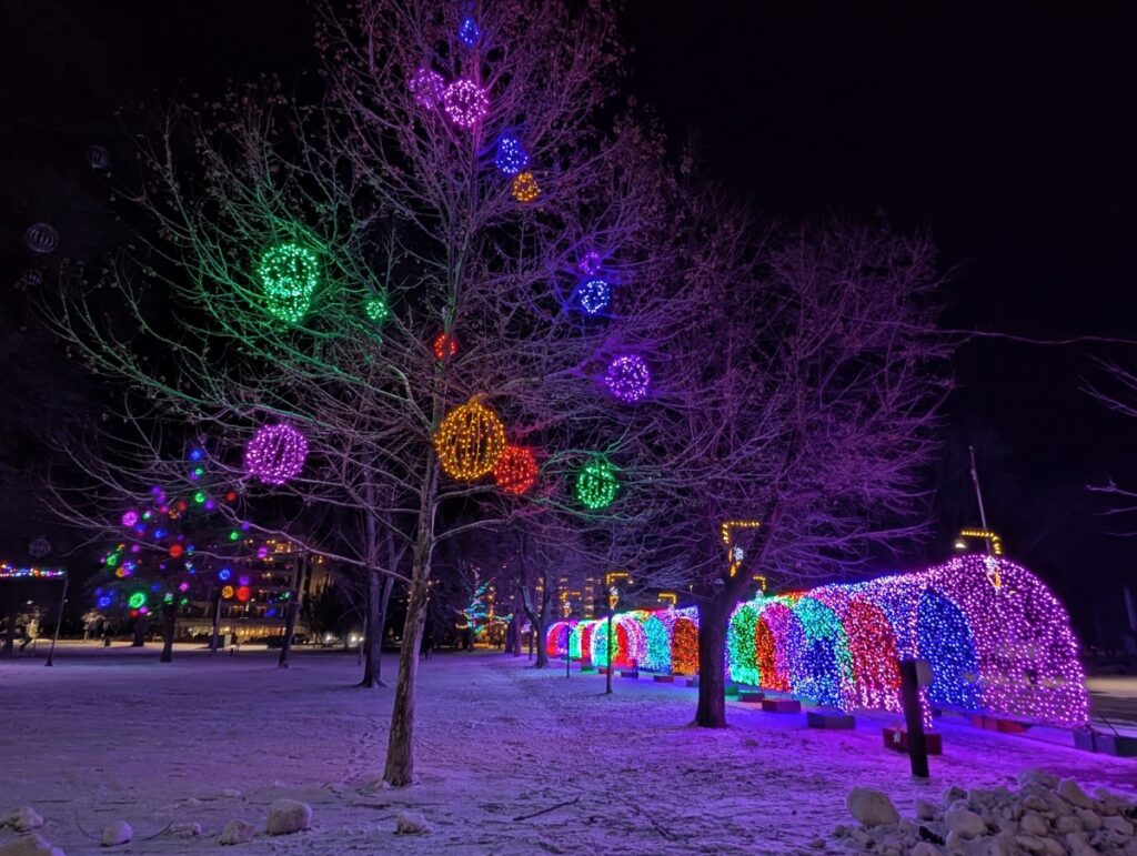 Winter night scene of lit up tunnel and decorations on trees in downtown Penticton