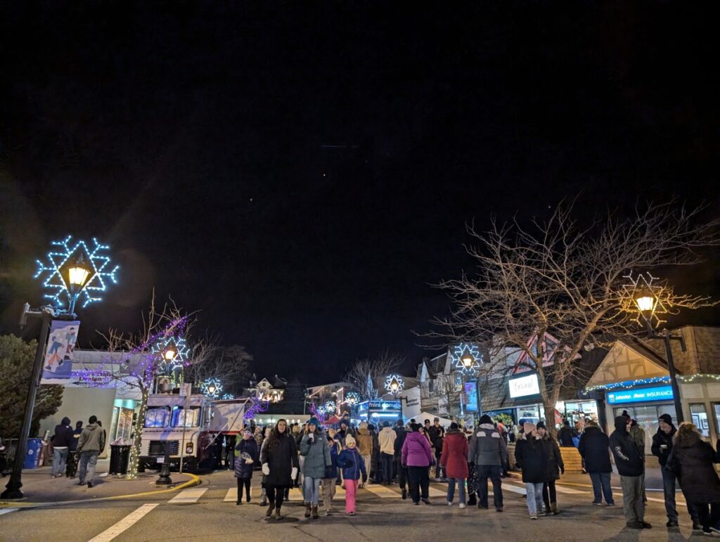 Street scene at Summerland Festival of Lights with groups of people walking on main road, with food trucks behind