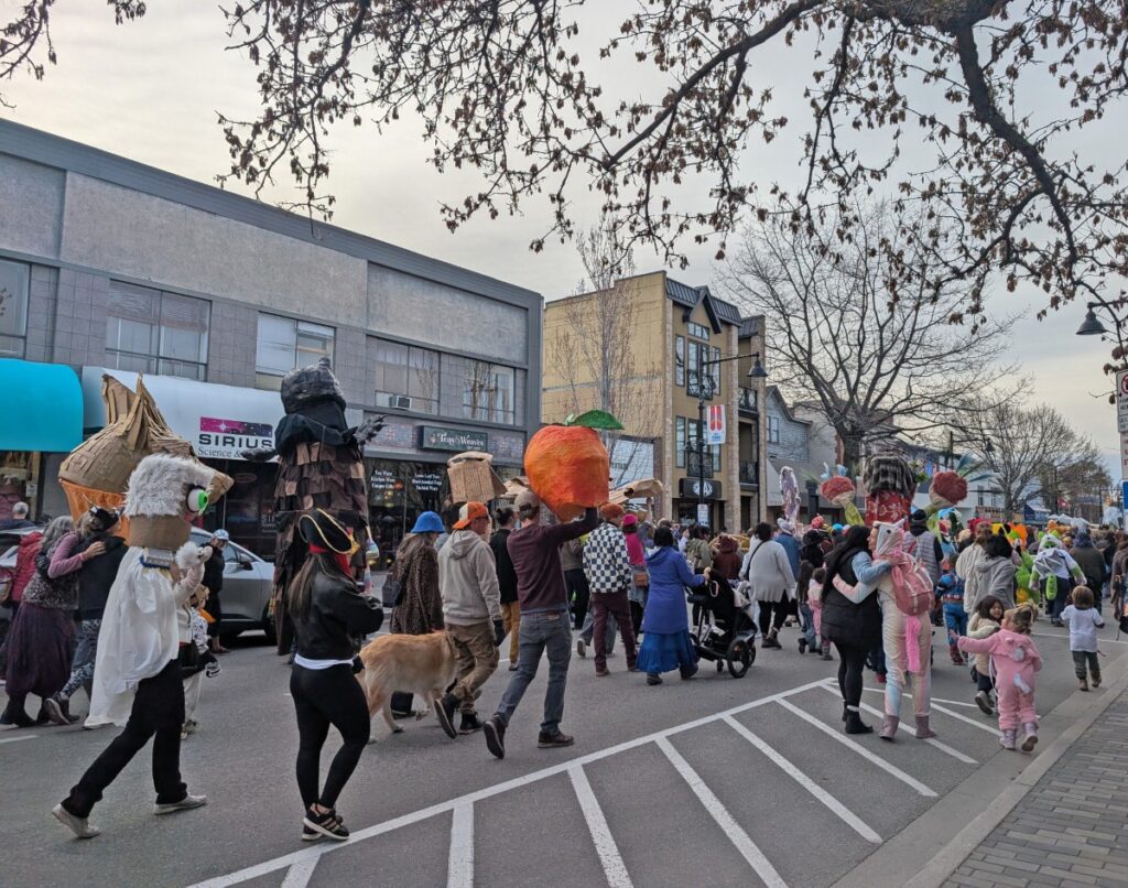 Street view of colourful street parade in downtown Penticton, with costumes and fun outfits